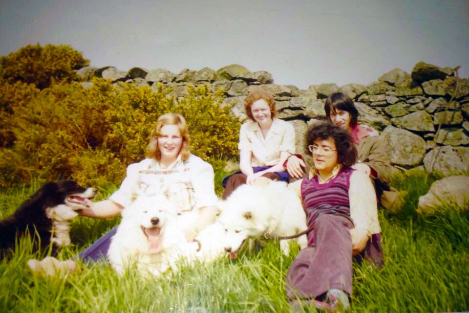 Brian, Liz and two friends sitting in a field with a dog